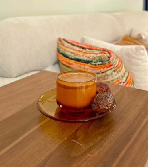 Cup of Arabic coffee served with fresh dates on a wooden table, reflecting Ras Al Khaimah’s traditional hospitality and local date culture.
