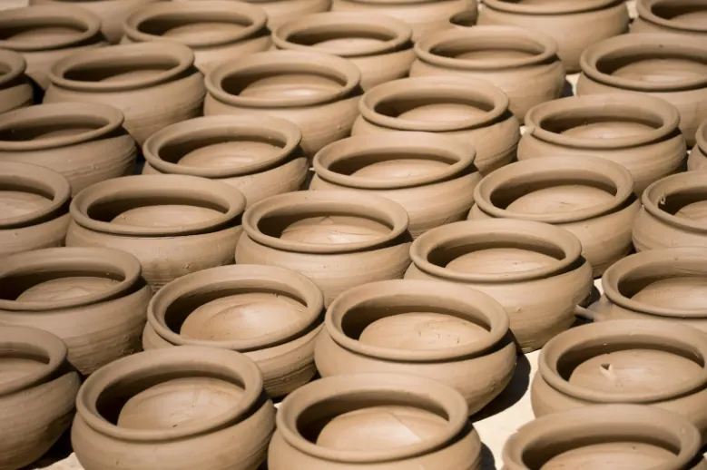 Rows of handcrafted clay pots drying in the sun, representing traditional pottery making in Ras Al Khaimah’s artisan craft industry.