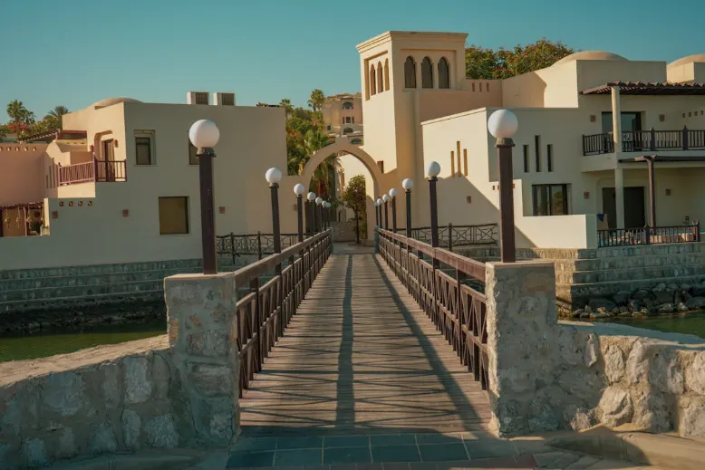 Wooden walkway leading to traditional-style waterfront buildings in Ras Al Khaimah, reflecting the emirate’s blend of historic charm and coastal heritage.
