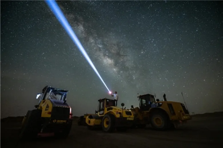 Night sky over the desert with a bright laser pointer aimed at the Milky Way, used during a stargazing tour in Ras Al Khaimah.