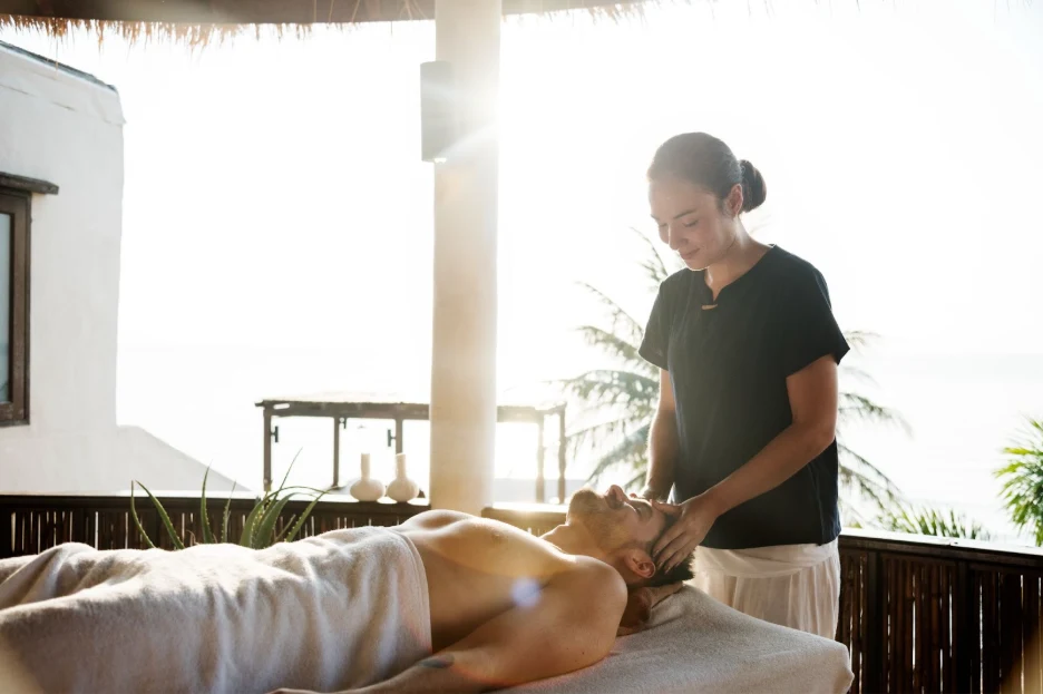 A woman providing a massage to a man at a peaceful resort 