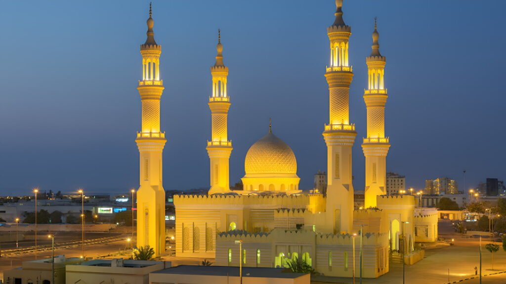 Grand illuminated mosque in Ras Al Khaimah at sunset