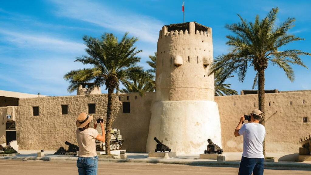 Tourists taking photos outside Umm Al Quwain National Museum at Al Ali Fort