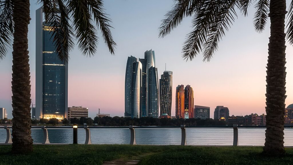 Beautiful sunset view at Abu Dhabi’s Corniche with palm trees framing the skyline